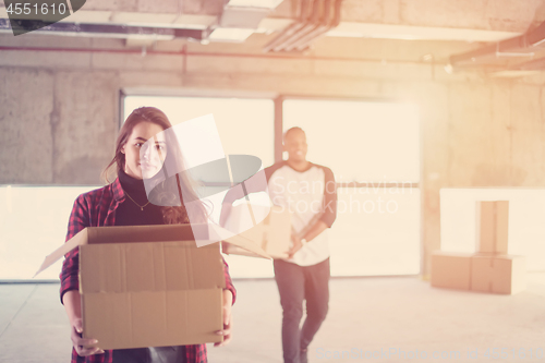 Image of multiethnic business team carrying cardboard boxes