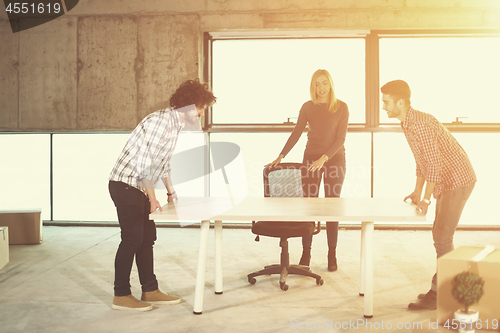 Image of business team carrying white table