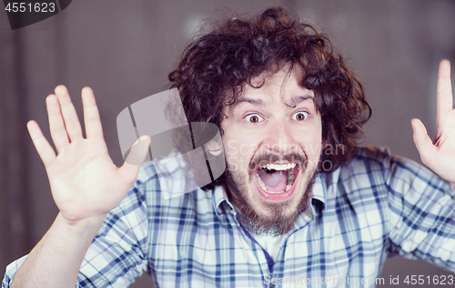 Image of casual businessman screaming in front of a concrete wall