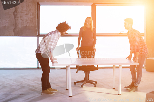 Image of business team carrying white table