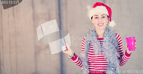 Image of young business woman wearing a red hat and blowing party whistle