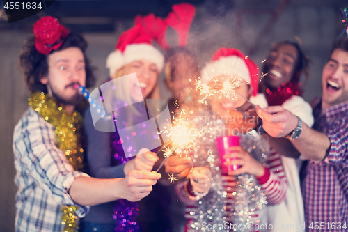 Image of multiethnic group of casual business people lighting a sparkler