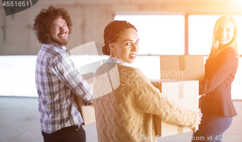 Image of business team carrying cardboard boxes