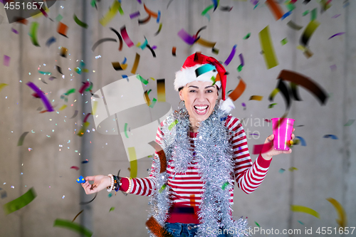 Image of business woman wearing a red hat and blowing party whistle