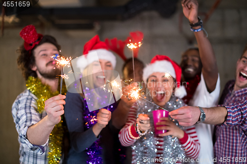 Image of multiethnic group of casual business people lighting a sparkler