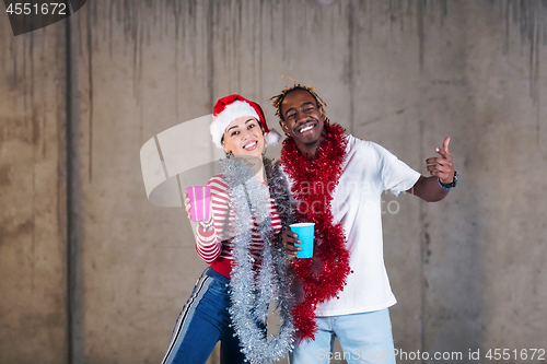 Image of young multiethnic business couple celebrating new year party