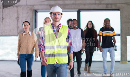 Image of young multiethnic business people walking through unfinished sta