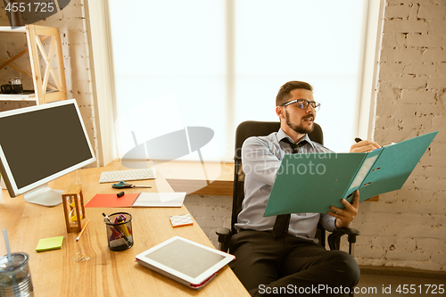 Image of A young businessman working in office after promotion