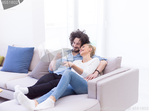 Image of Young couple on the sofa watching television