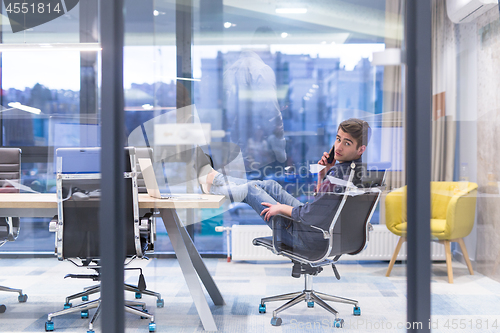 Image of young businessman relaxing at the desk