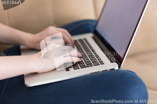 Image of young woman on sofa at home websurfing