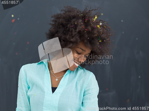 Image of black woman blowing confetti in the air