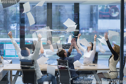 Image of startup Group of young business people throwing documents