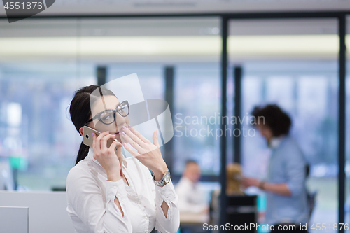 Image of Elegant Woman Using Mobile Phone in startup office building