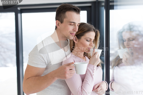 Image of young couple enjoying morning coffee by the window