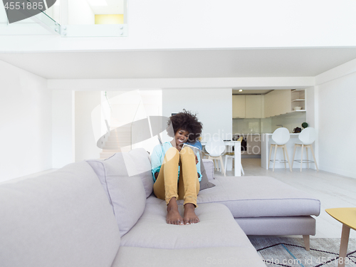 Image of african american woman at home using digital tablet