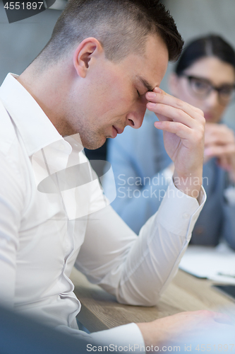 Image of young businessman relaxing at the desk