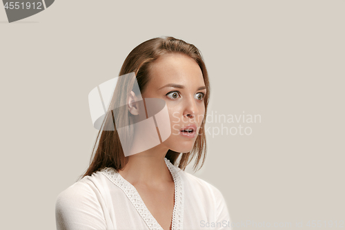 Image of Beautiful woman looking suprised isolated on gray