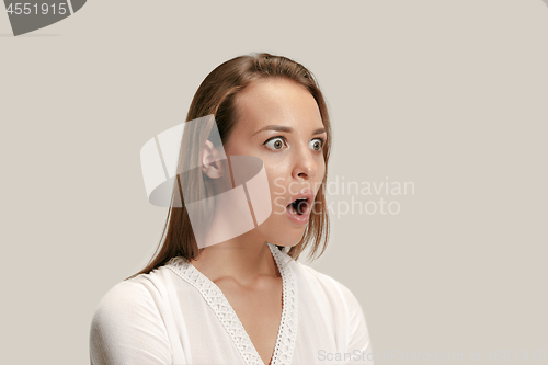Image of Beautiful woman looking suprised isolated on gray