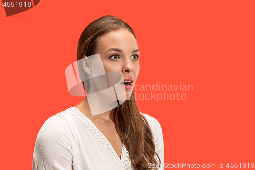 Image of Beautiful woman looking suprised isolated on red