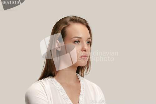 Image of The serious business woman standing and looking at camera against gray background.