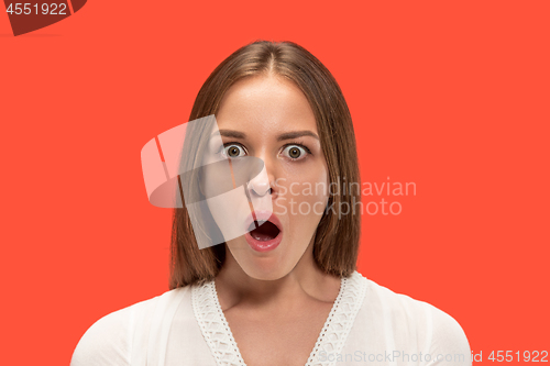 Image of Beautiful woman looking suprised isolated on red