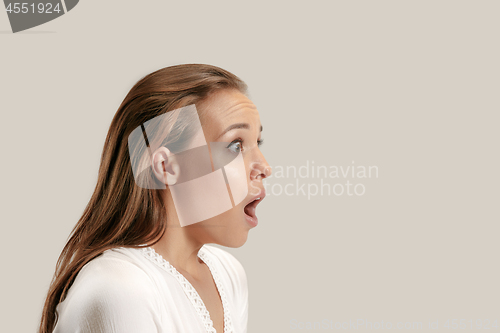 Image of Beautiful woman looking suprised isolated on gray