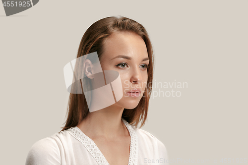 Image of The serious business woman standing and looking at camera against gray background.