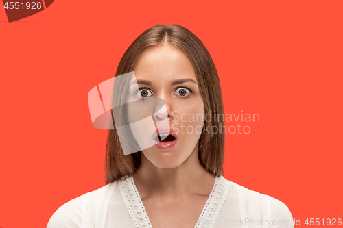 Image of Beautiful woman looking suprised isolated on red