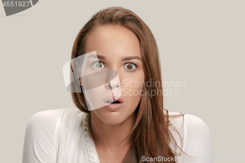 Image of Beautiful woman looking suprised isolated on gray