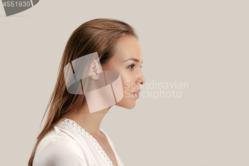 Image of The serious business woman standing and looking at camera against gray background.