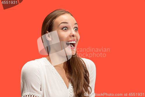 Image of Beautiful woman looking suprised isolated on red