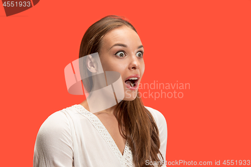 Image of Beautiful woman looking suprised isolated on red