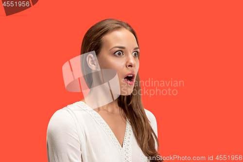 Image of Beautiful woman looking suprised isolated on red