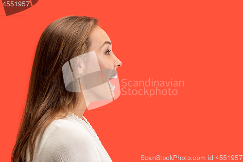 Image of The happy business woman standing and smiling against red background.