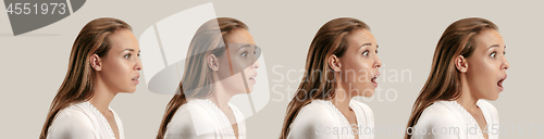 Image of Beautiful woman looking suprised isolated on gray