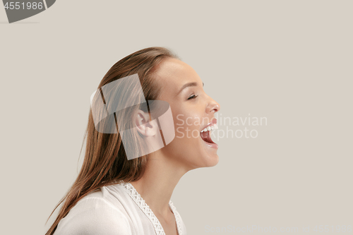 Image of The happy business woman standing and smiling against gray background.