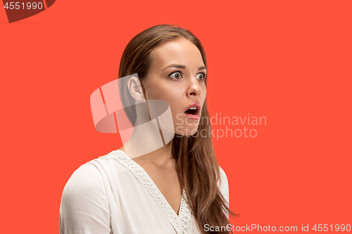 Image of Beautiful woman looking suprised isolated on red