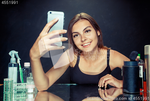 Image of Beauty woman with makeup. Beautiful girl looking at the mobile phone and making selfie photo