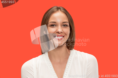 Image of The happy business woman standing and smiling against red background.