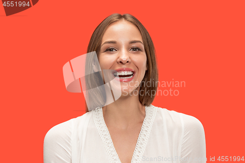 Image of The happy business woman standing and smiling against red background.