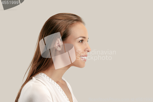 Image of The happy business woman standing and smiling against gray background.