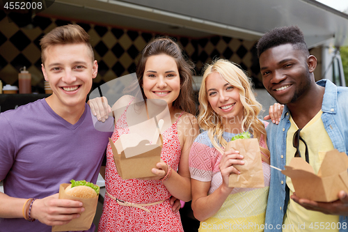 Image of happy friends with wok and burger at food truck