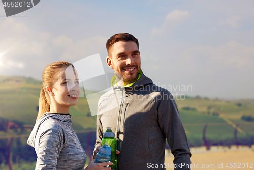 Image of couple with bottles of water after sports outdoors