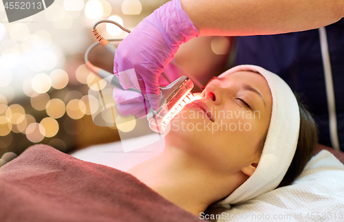 Image of young woman having face microdermabrasion at spa