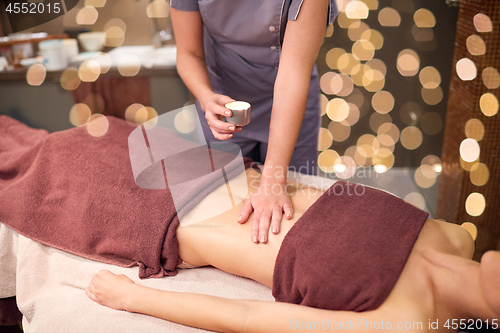 Image of woman lying and having massage with hot oil at spa