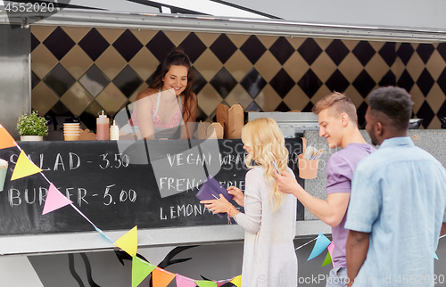 Image of queue of customers and saleswoman at food truck