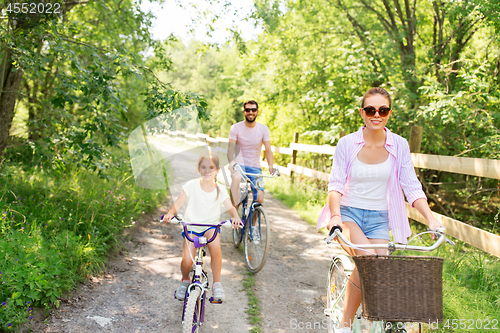 Image of happy family with bicycles in summer park