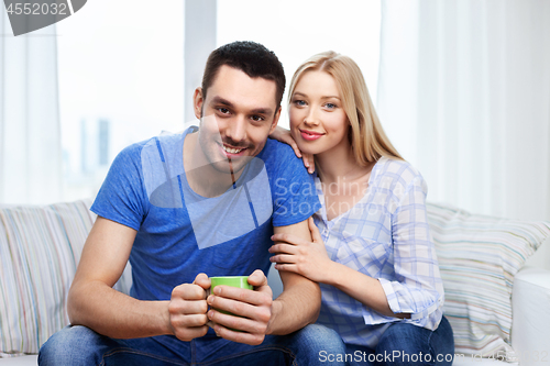 Image of happy smiling couple sitting on sofa at home