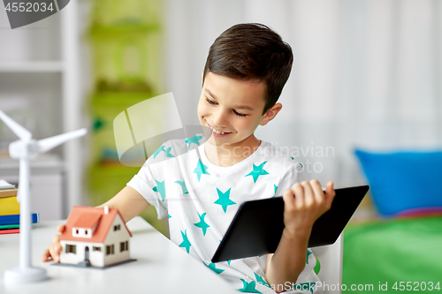 Image of boy with tablet, toy house and wind turbine